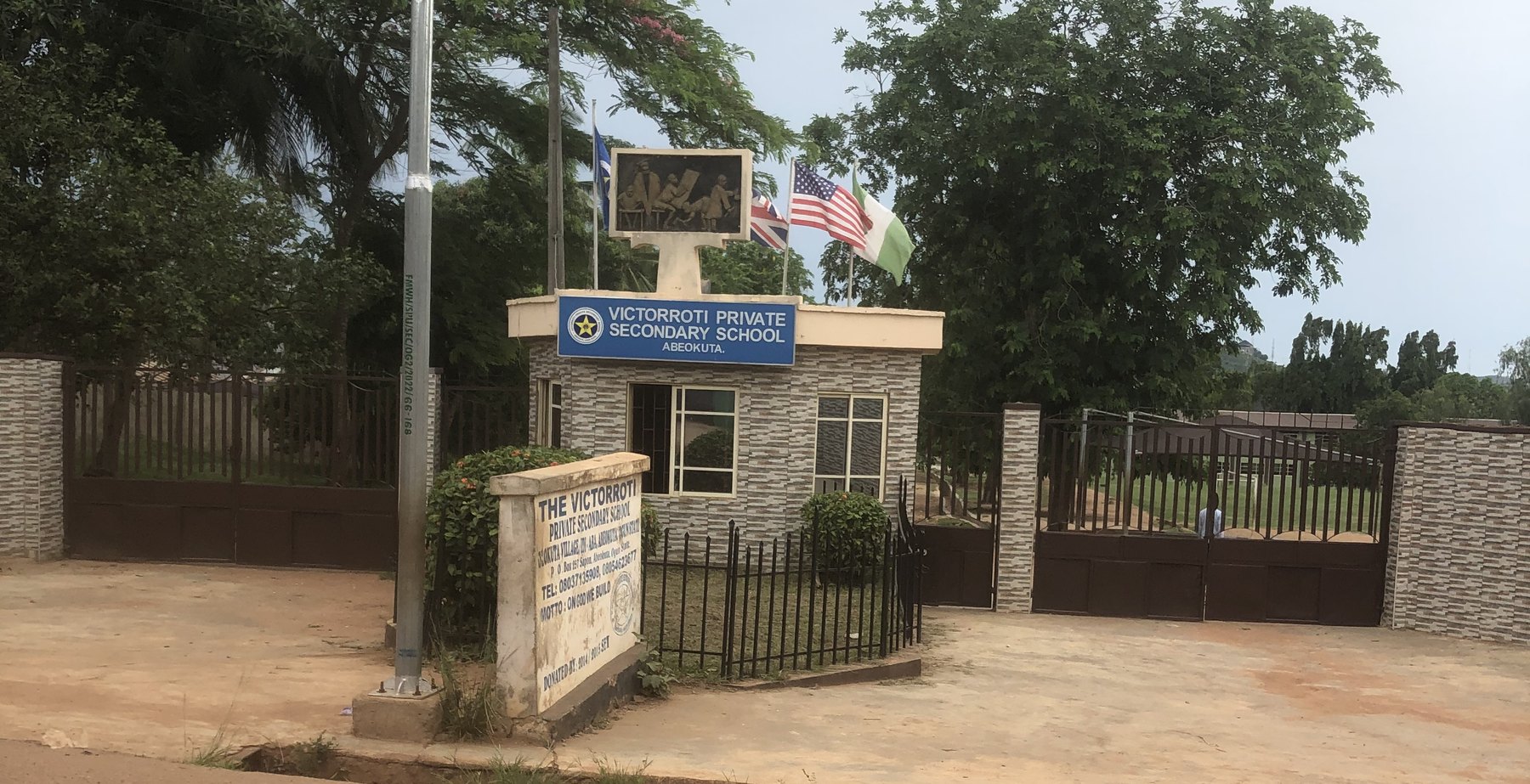 The gate of Victorroti Private Secondary School in Idi-Aba, Abeokuta, with its blue sign and flags